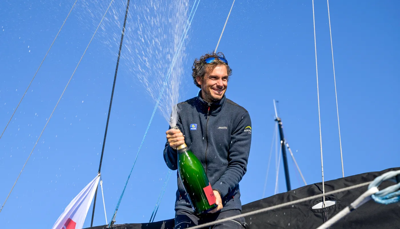 Le skipper de l'Imoca MACIF Santé Prévoyance, Charlie Dalin (FRA), fêtant au champagne sa première place dans la New York Vendee, aux Sables d'Olonne